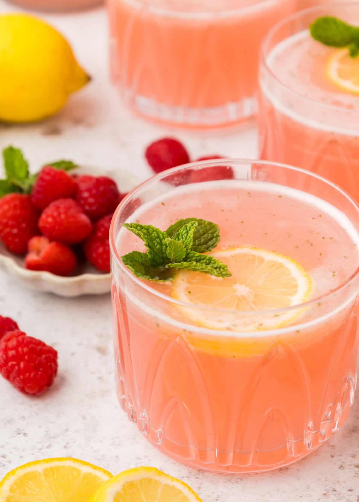 Pink Lemonade in a glass with lemon and mint.