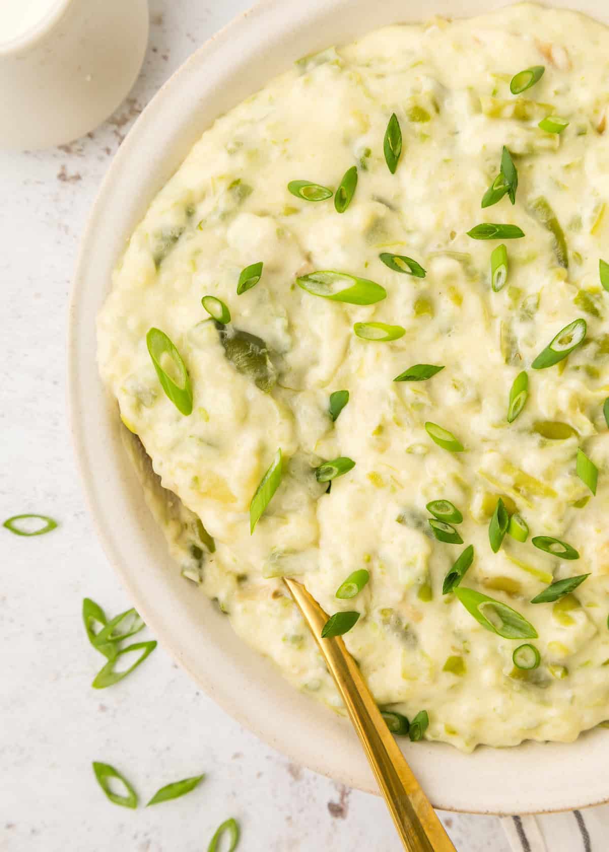 Green Bean Smashed Potatoes served in a bowl with a spoon.