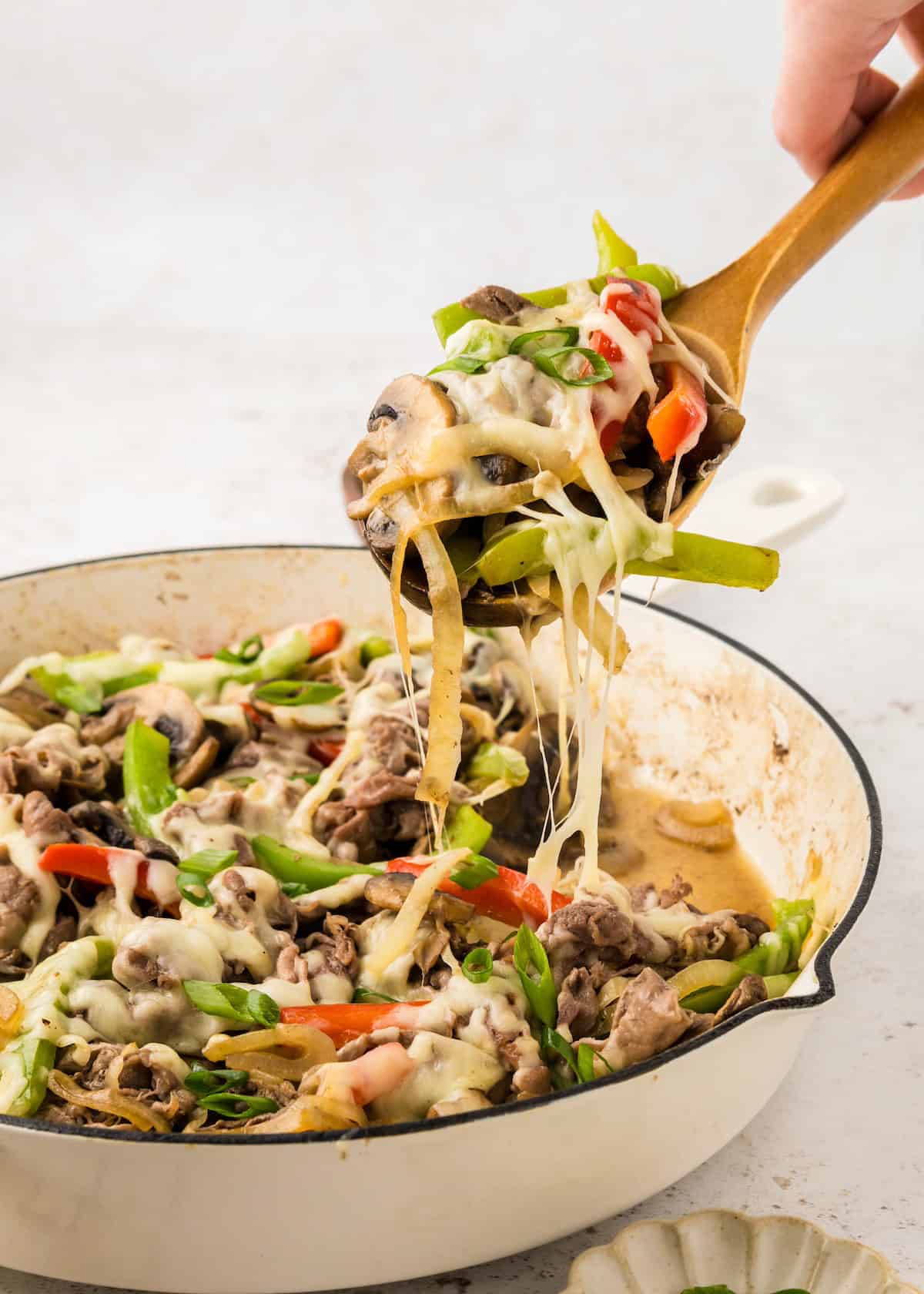Scooping Cheesesteak Skillet out of pan.