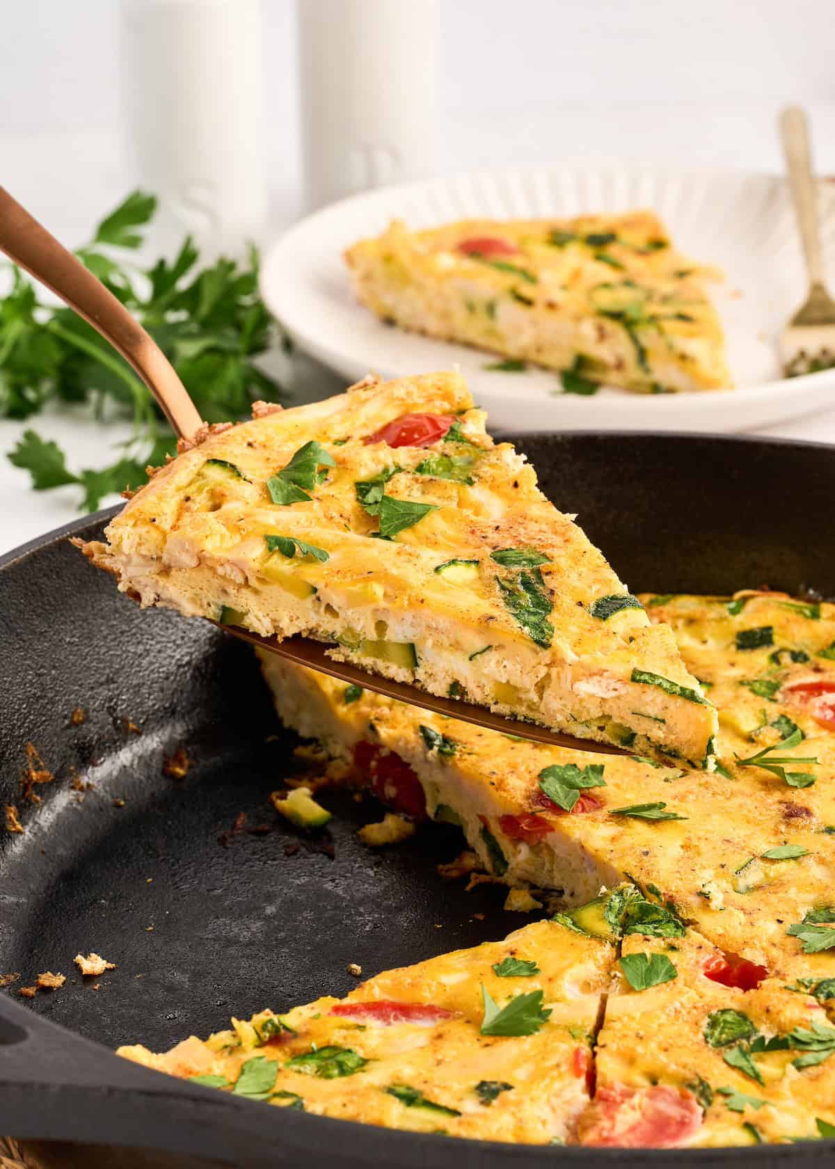 chicken frittata slice being taken out of the pan.