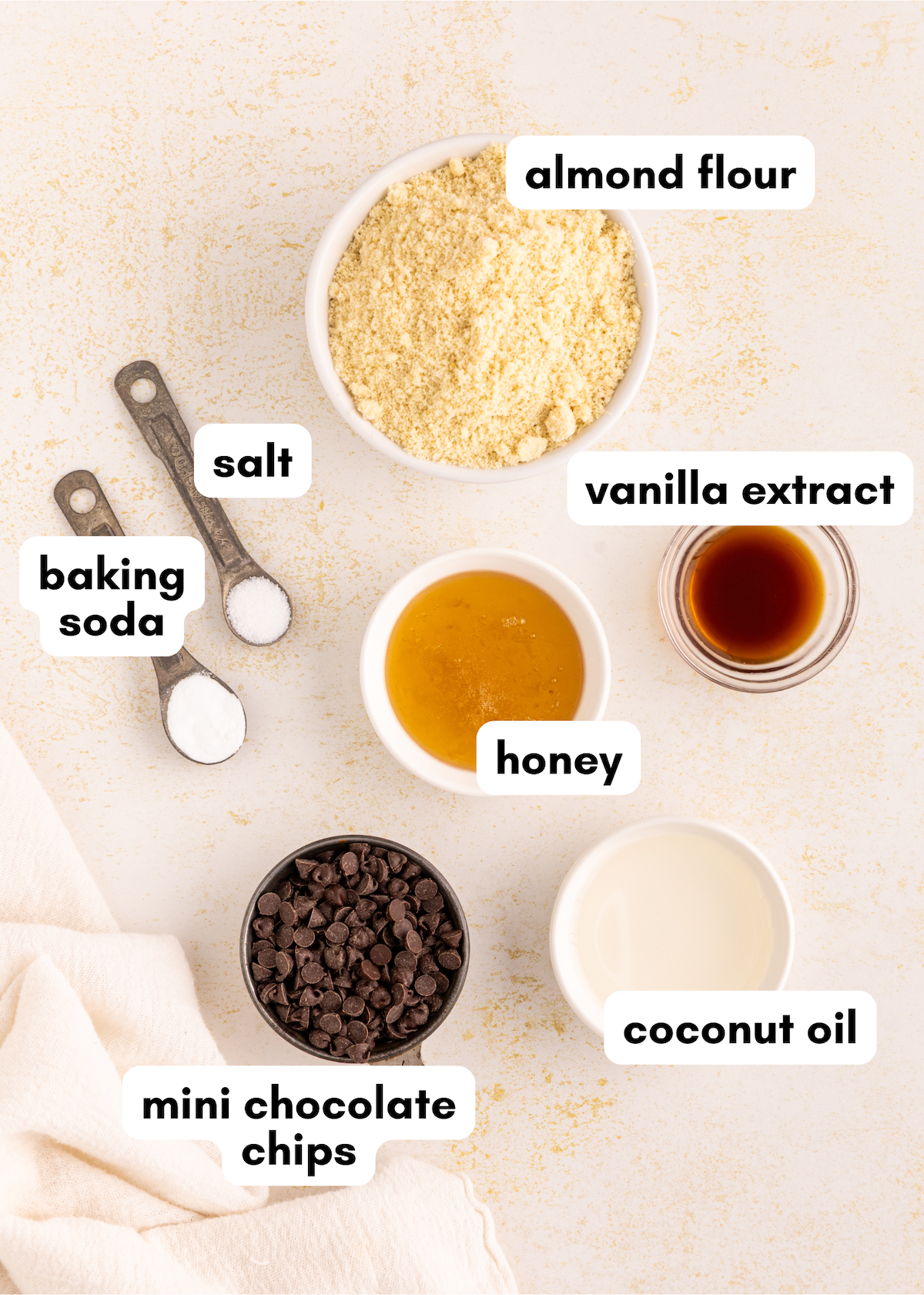 Baking ingredients for Edible Cookie Dough: almond flour, vanilla, honey, coconut oil, chips, salt.
