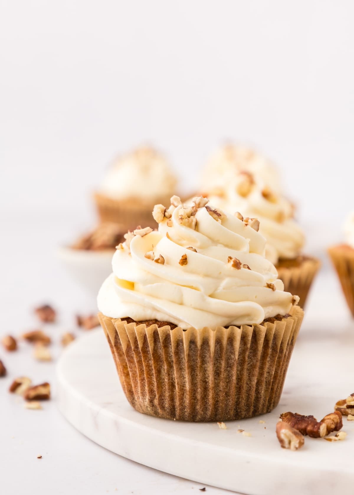 Cupcake in wrapper, topped with crushed nuts.
