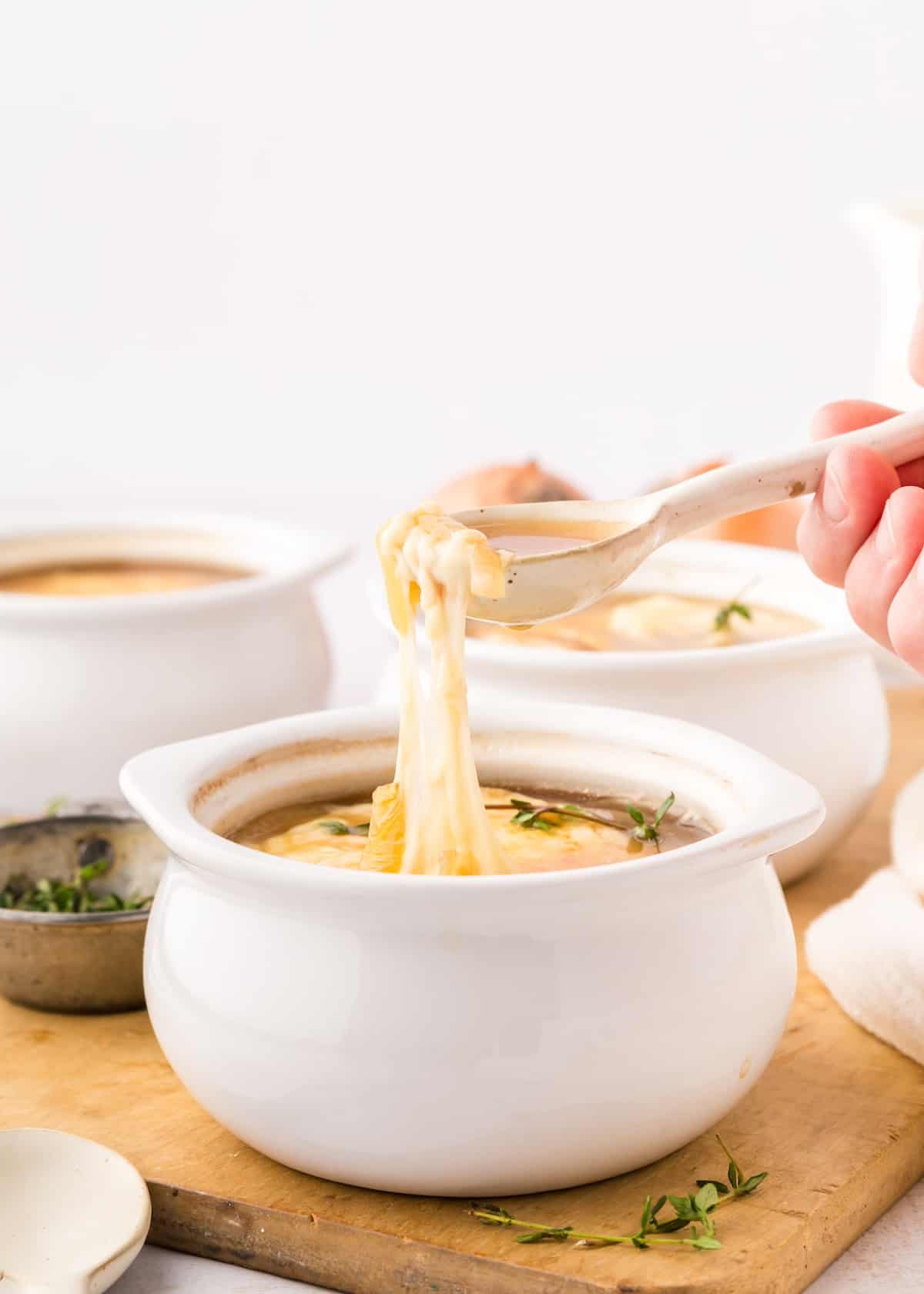 french onion soup with spoon scooping melty cheese