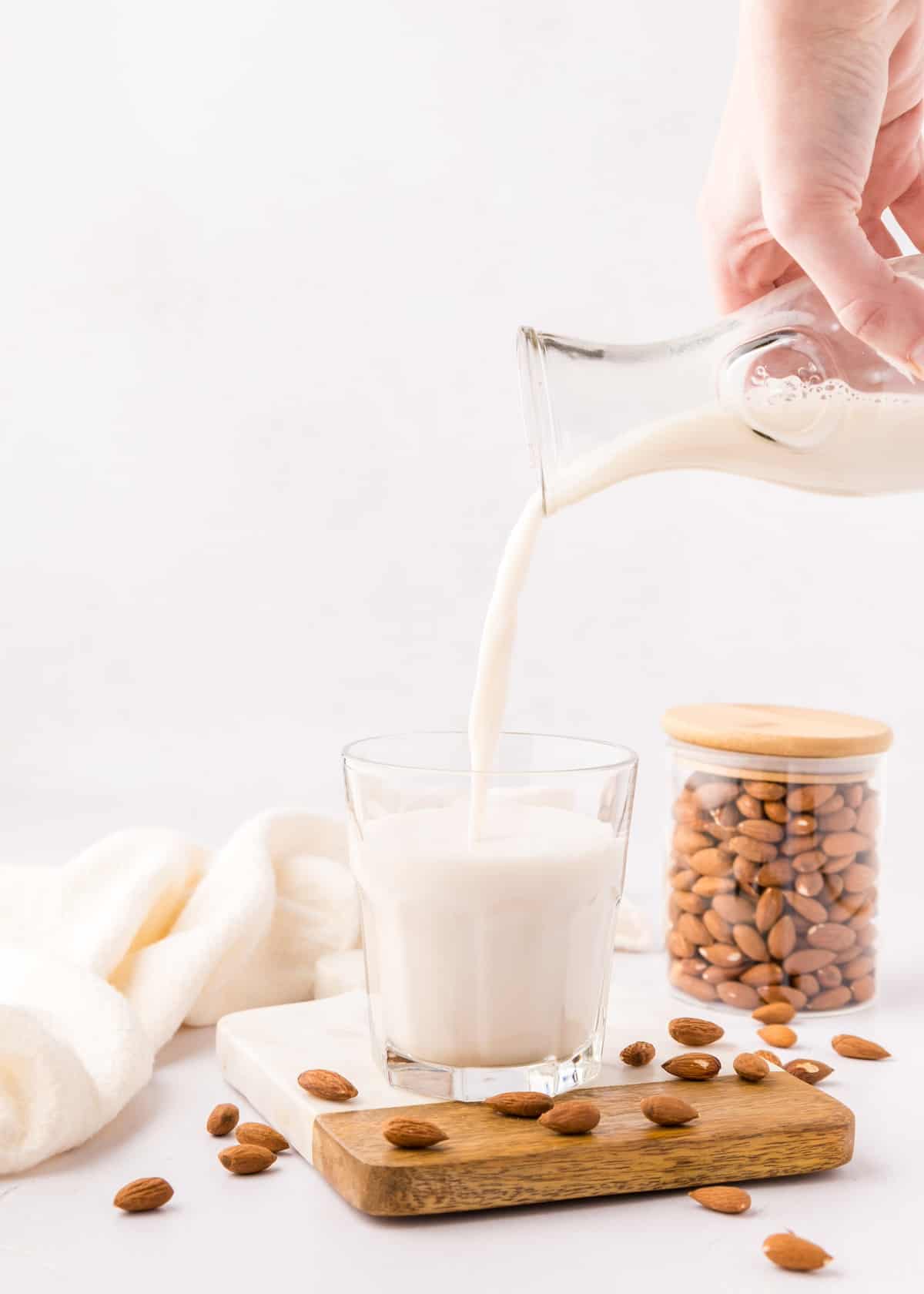 Pouring almond milk into a glass.