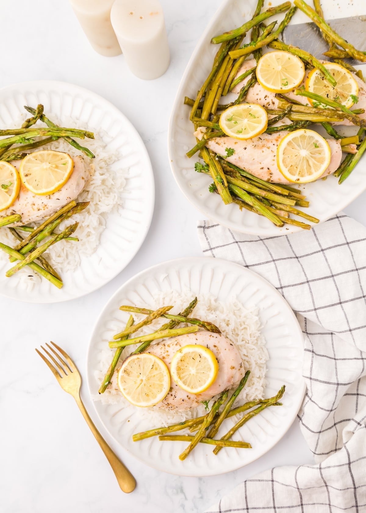 Sheet Pan Lemon Chicken with asparagus on rice, served alongside a gold fork and platter.