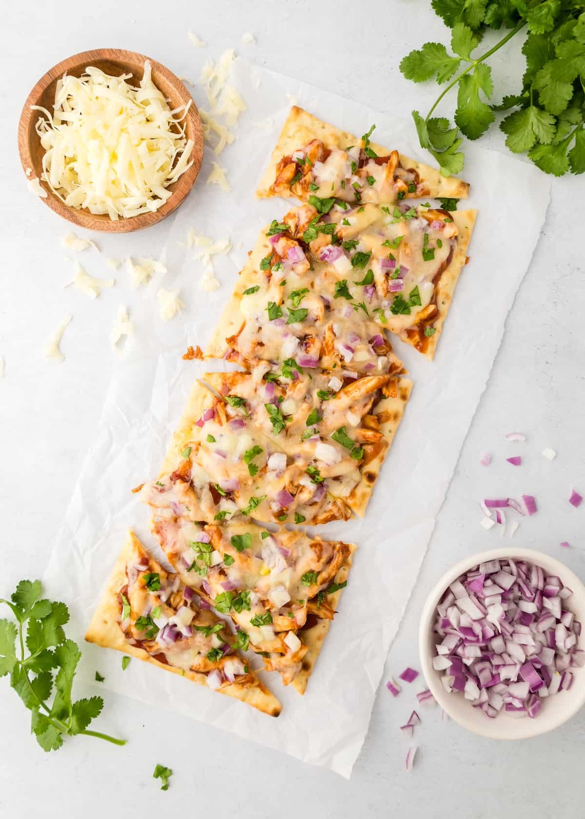 BBQ chicken flatbread on parchment paper.