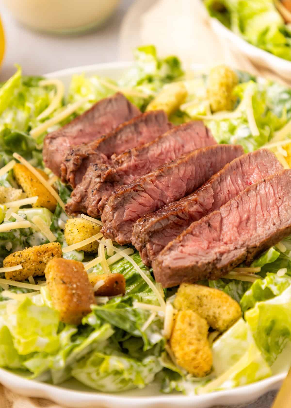 Steak Caesar Salad with croutons, crisp lettuce, and grated cheese.