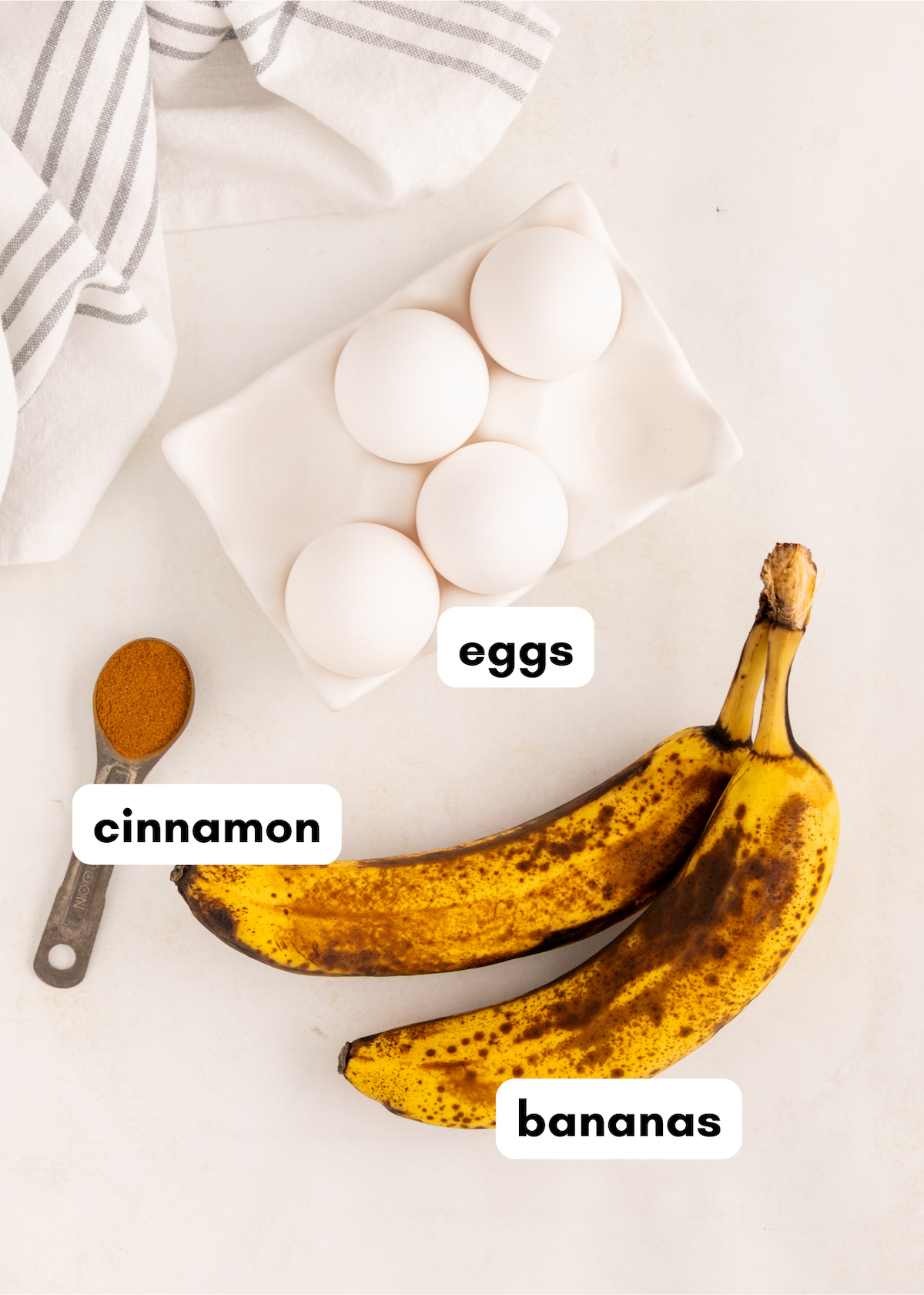 3 Ingredient Banana Pancakes made with overripe bananas, eggs, and cinnamon on a white surface.