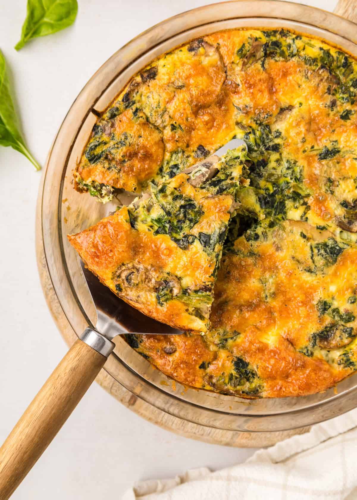 Crustless spinach quiche with piece cut out.
