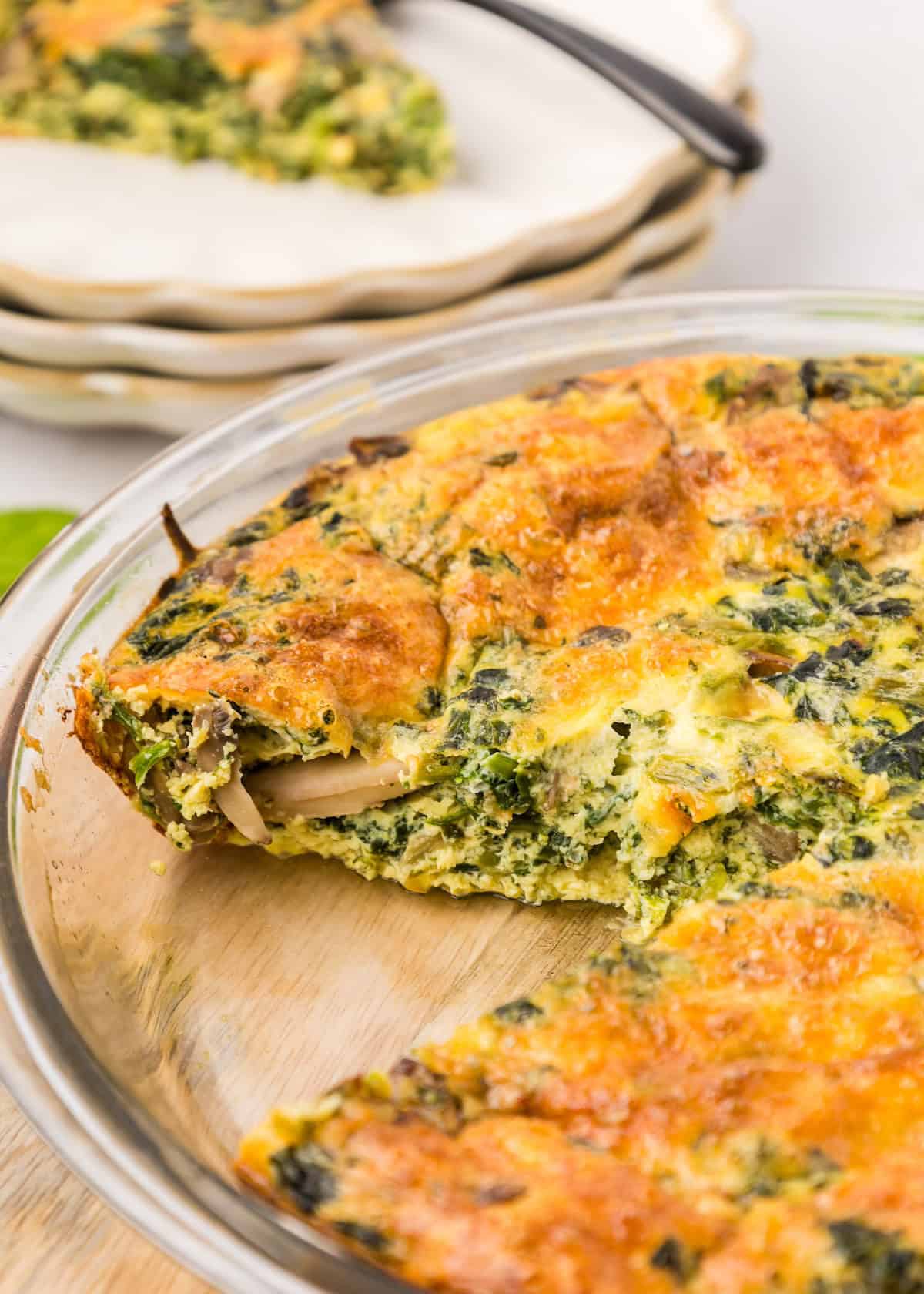 crustless spinach quiche in glass pie dish