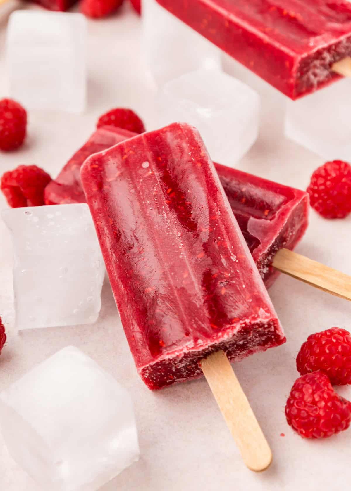 raspberry popsicles with ice cubes and raspberries