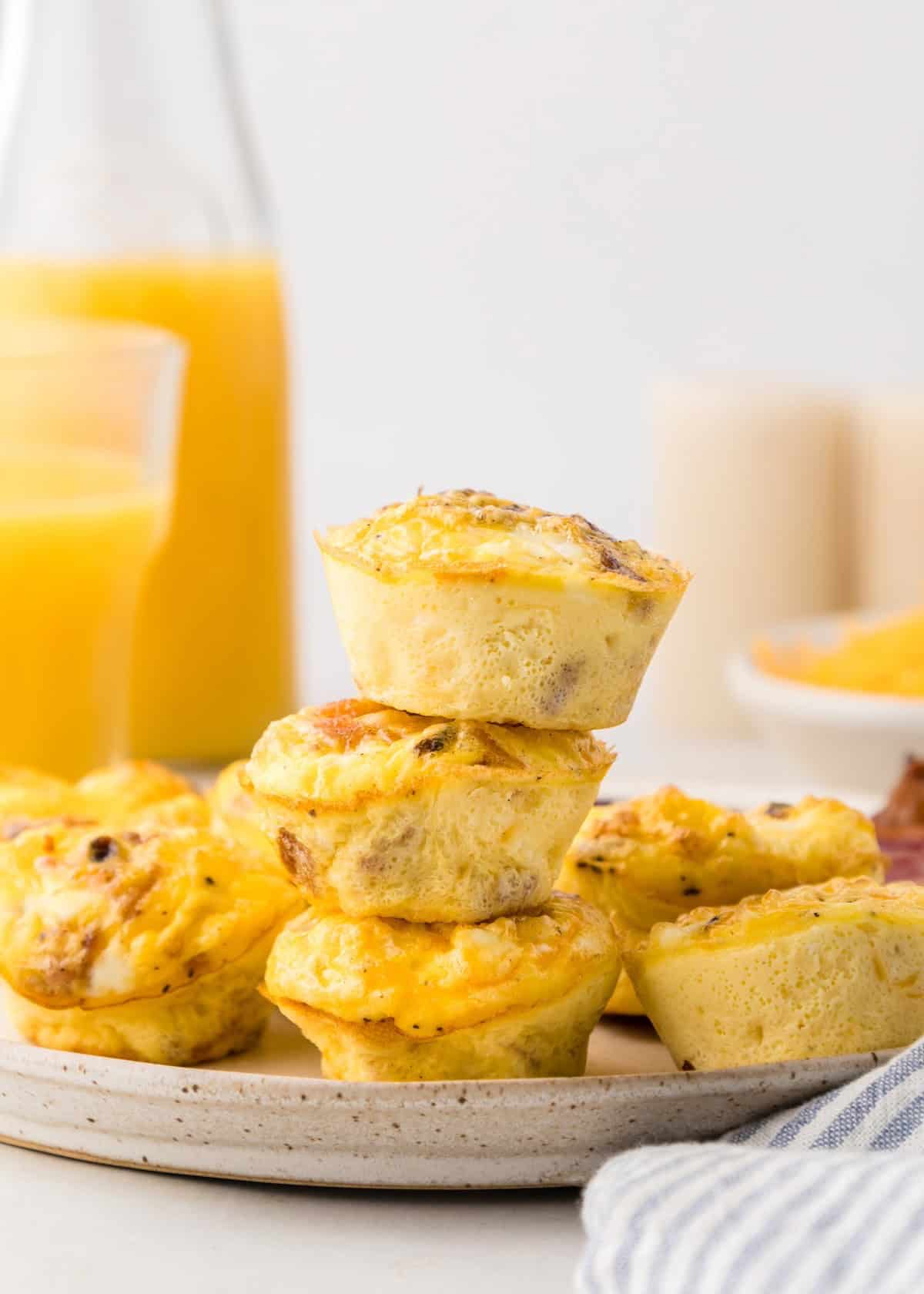 Bacon egg muffins stacked on a plate.