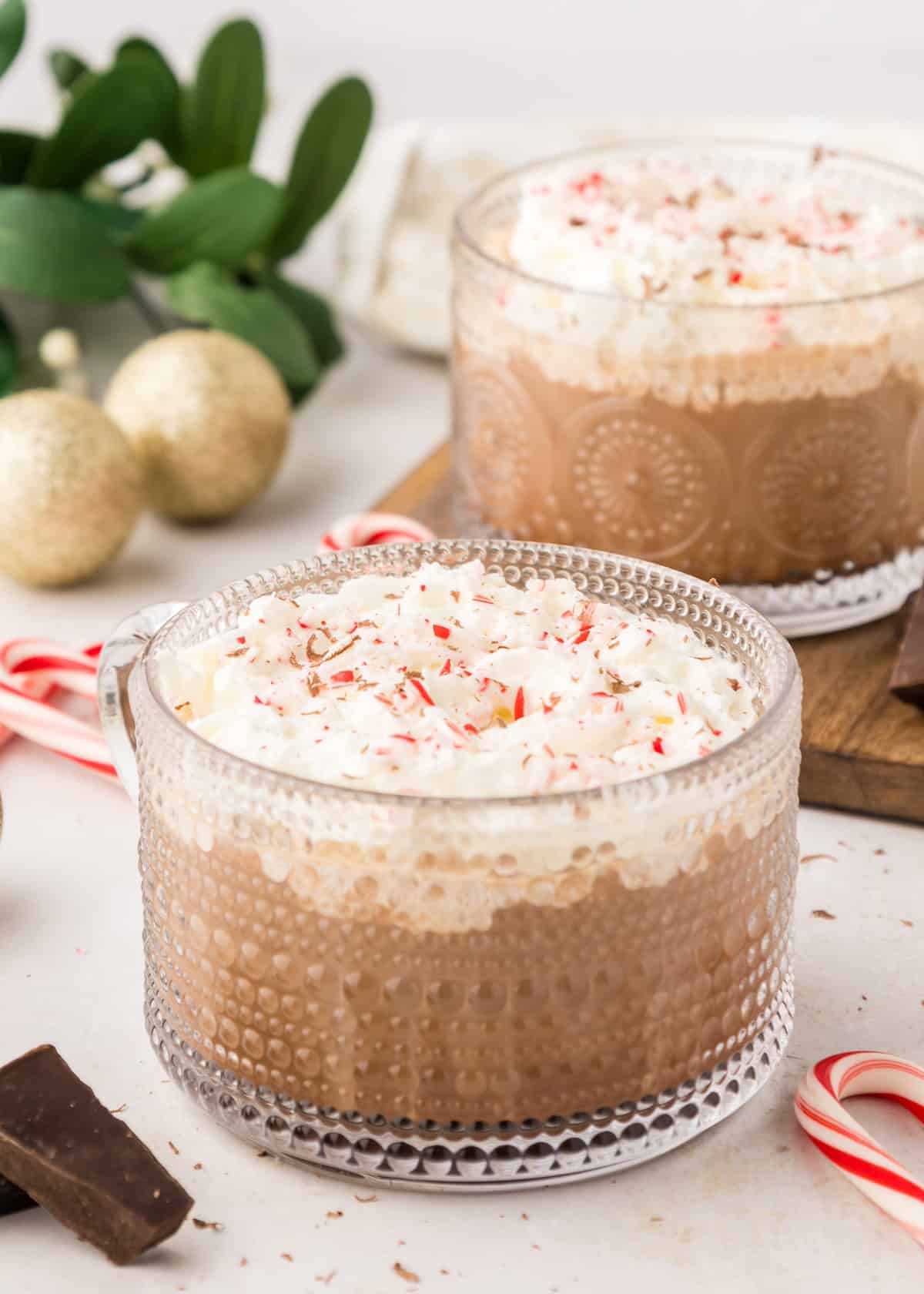 Peppermint mocha in glass mug with crushed candy canes.