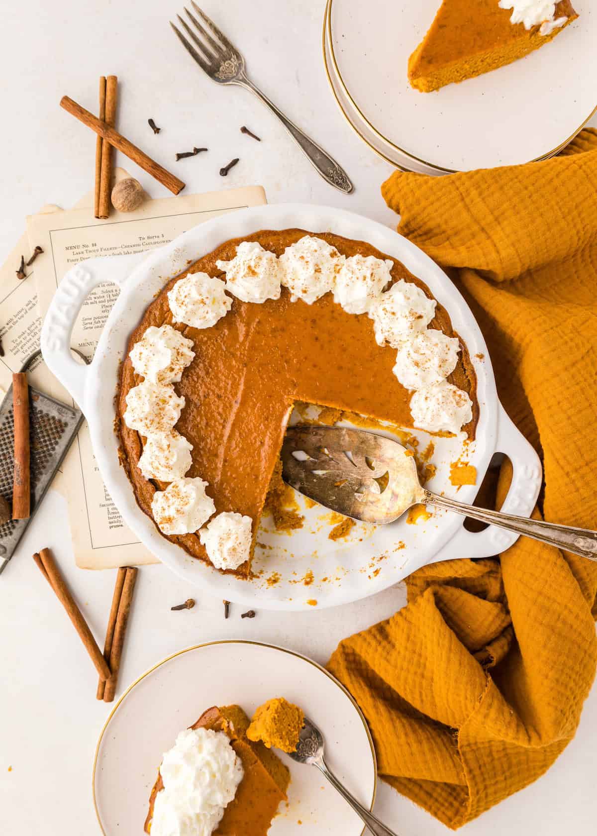 crustless pumpkin pie with slice taken out and served on plate.