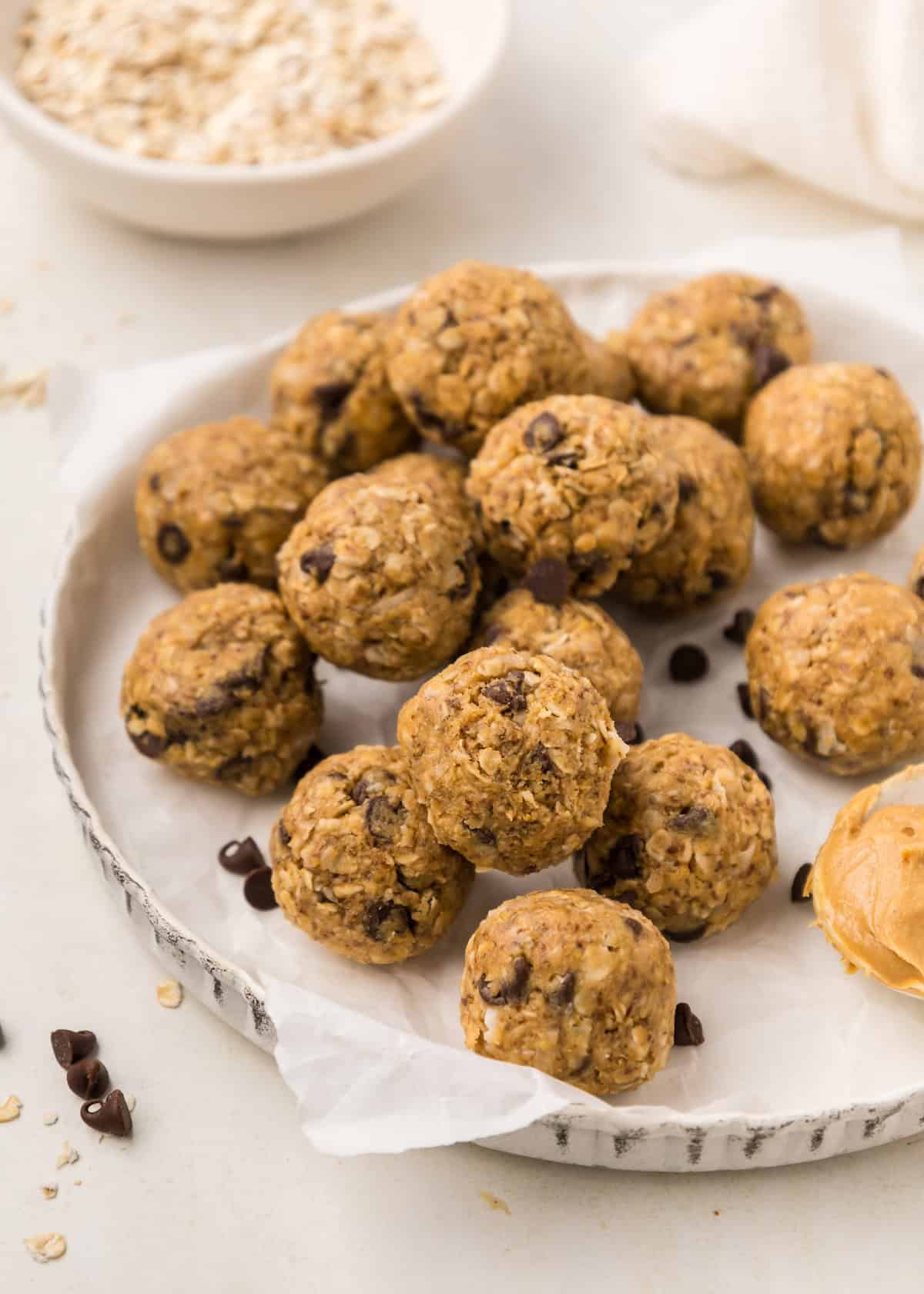 A plate of No Bake Protein Balls with oatmeal, chocolate chips, and a spoonful of peanut butter.