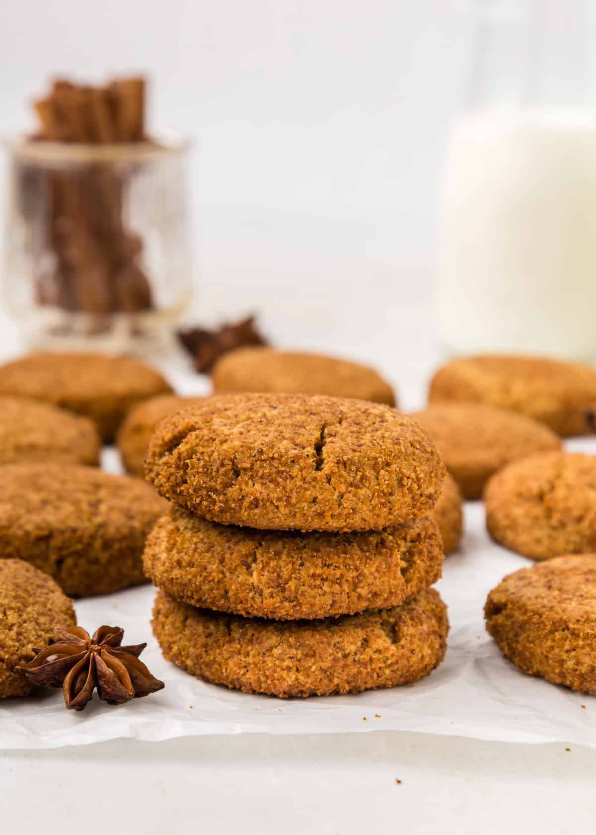 Molasses cookies stacked with an anise star in the foreground.