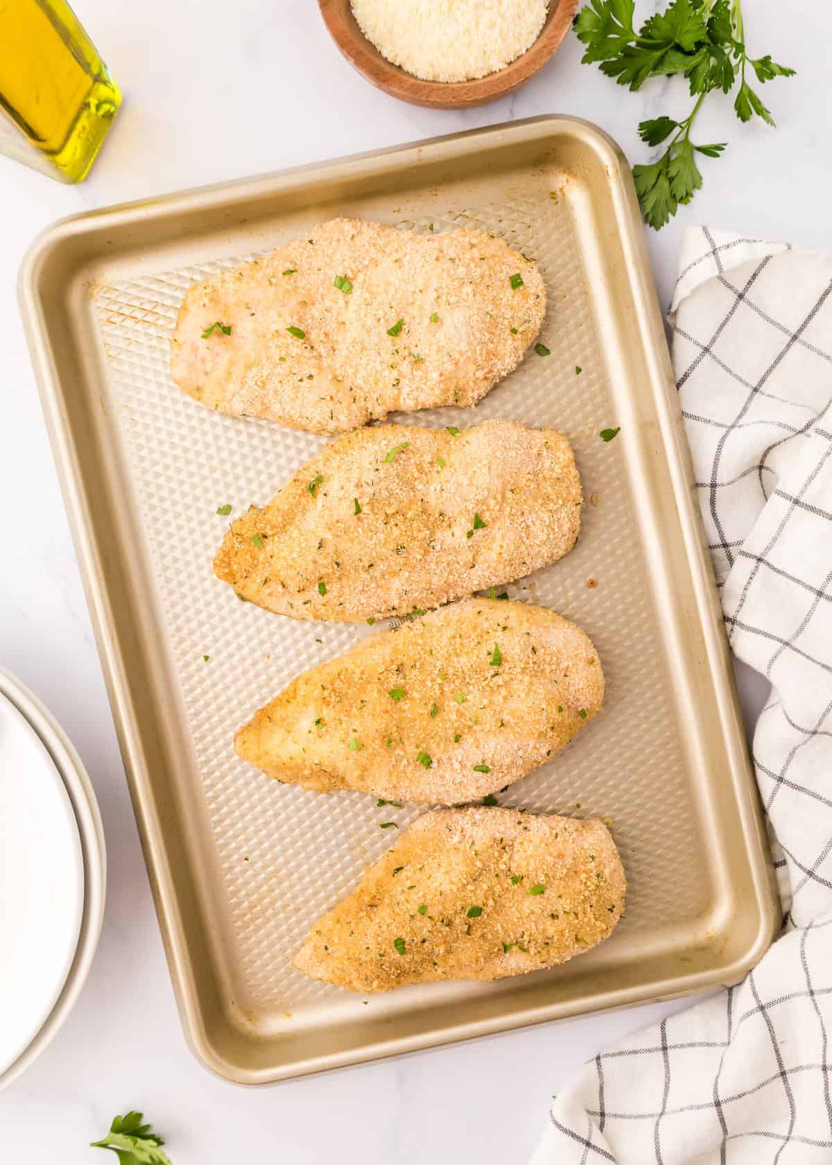 breaded parmesan chicken on baking sheet