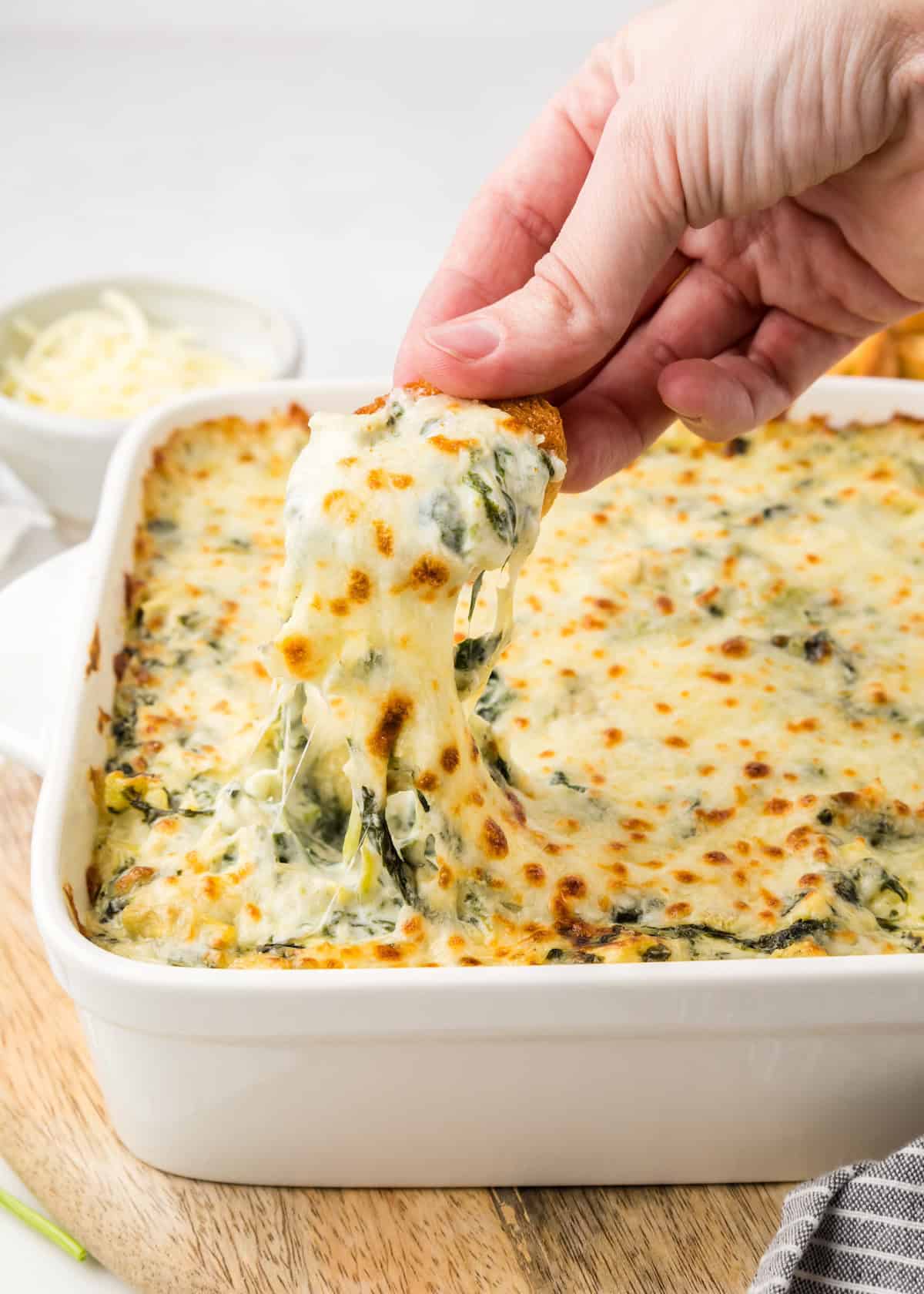 Spinach Artichoke Dip being dipped with bread.