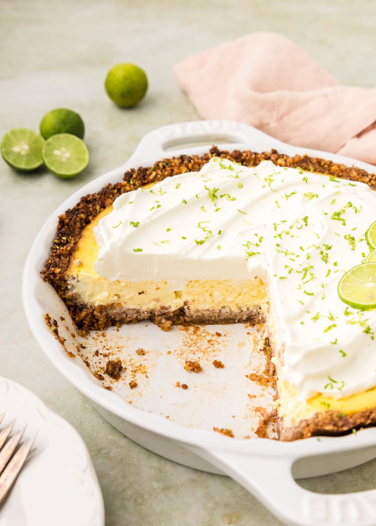 Key Lime Pie in pie dish with slice taken out.