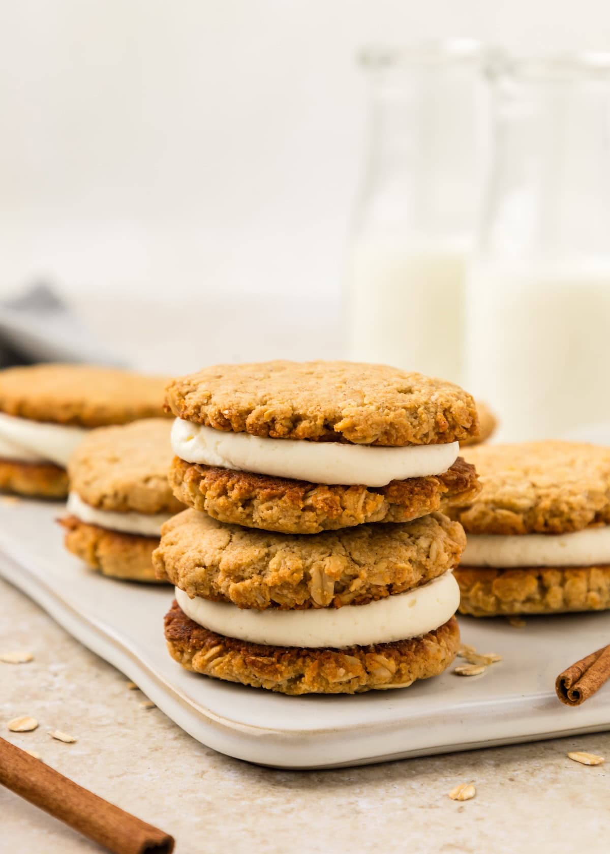 Oatmeal Cream Pies stacked on a tray, ready to enjoy with cold bottles of milk.