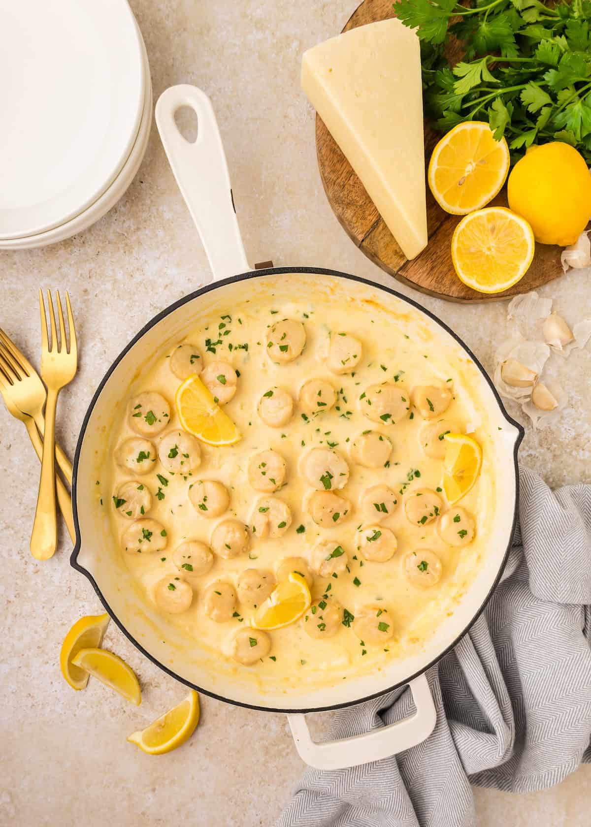 Pan of creamy lemon garlic shrimp and Creamy Garlic Scallops, garnished with lemon and parsley.