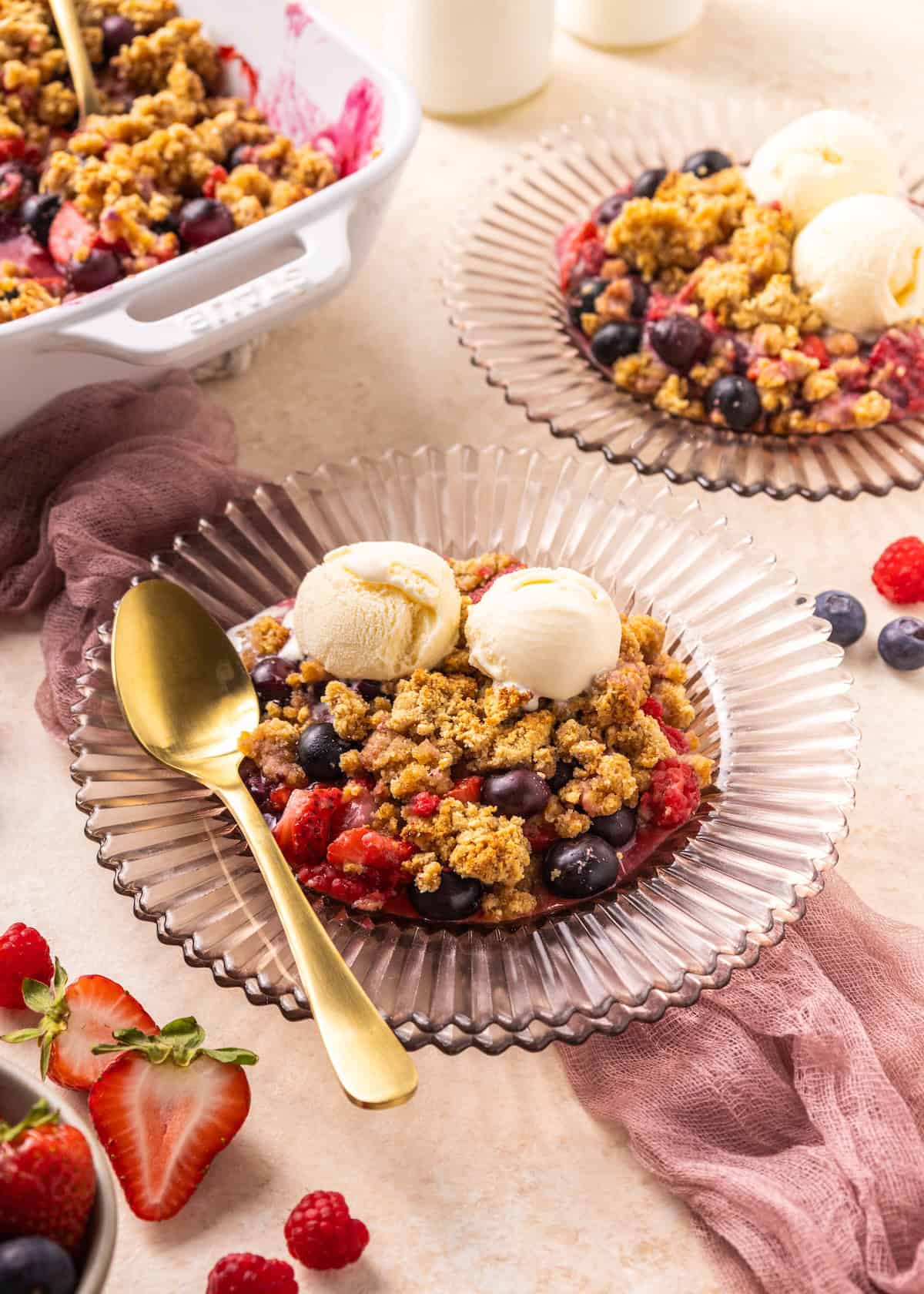Mixed Berry Cobbler on a pink plate with ice cream.