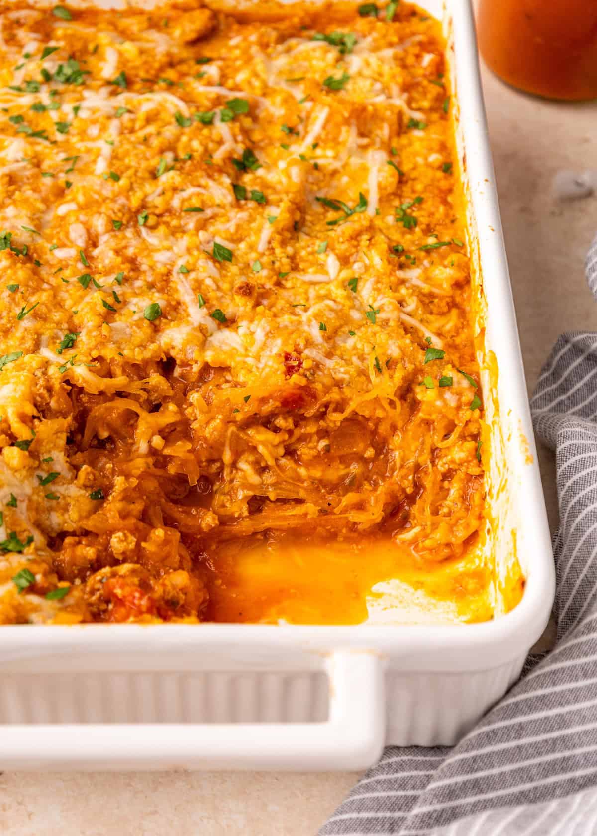 Baked Spaghetti Squash Casserole with a cheesy golden top, one serving removed.