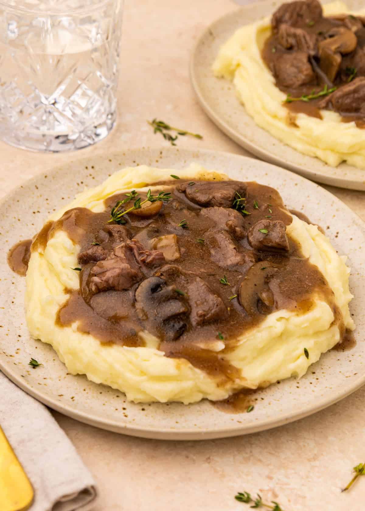 Mashed potatoes topped with Crockpot Beef Tips and Gravy, mushrooms, and brown gravy.