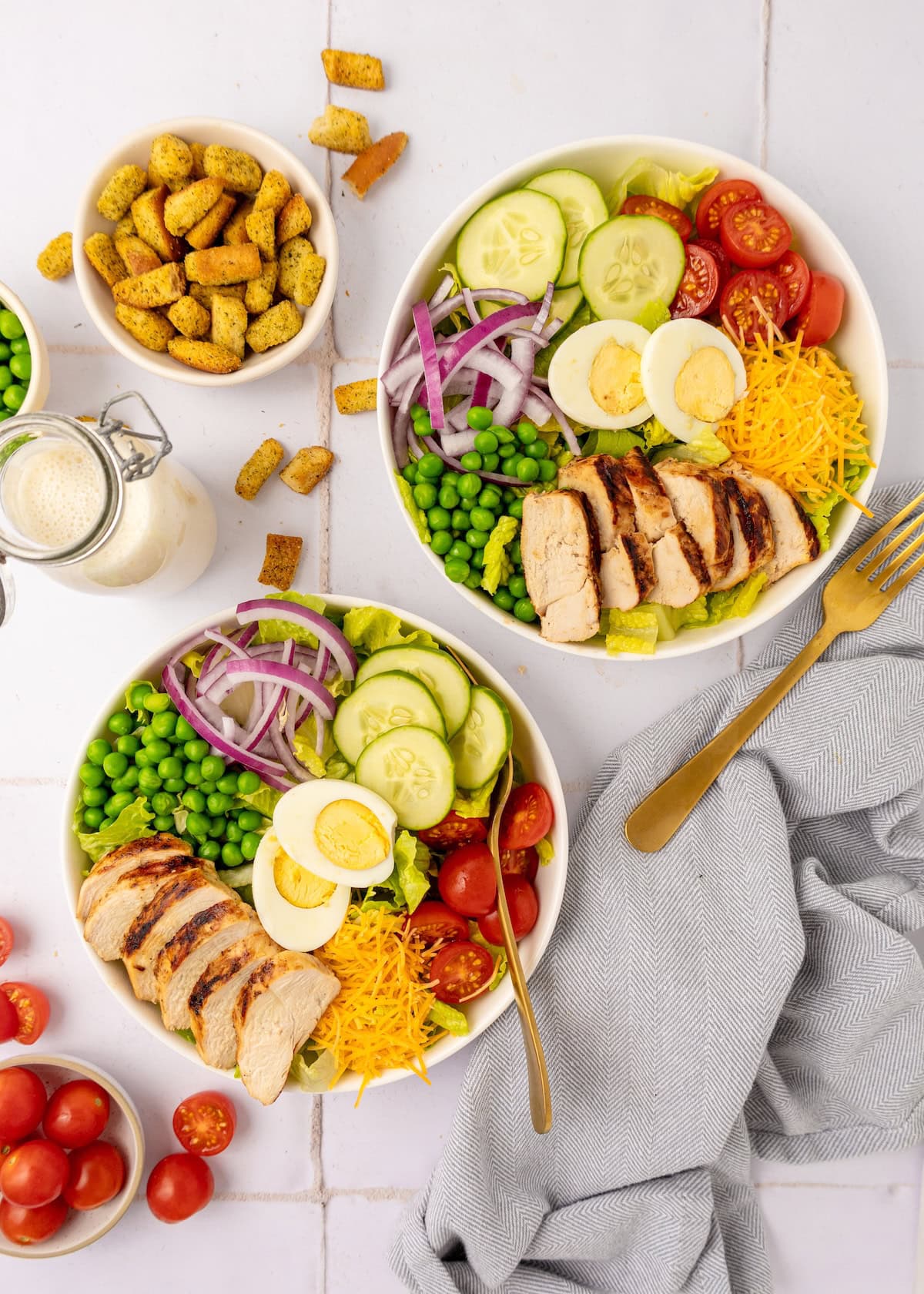 Grilled Chicken Salad served on dishes with croutons and dressing.