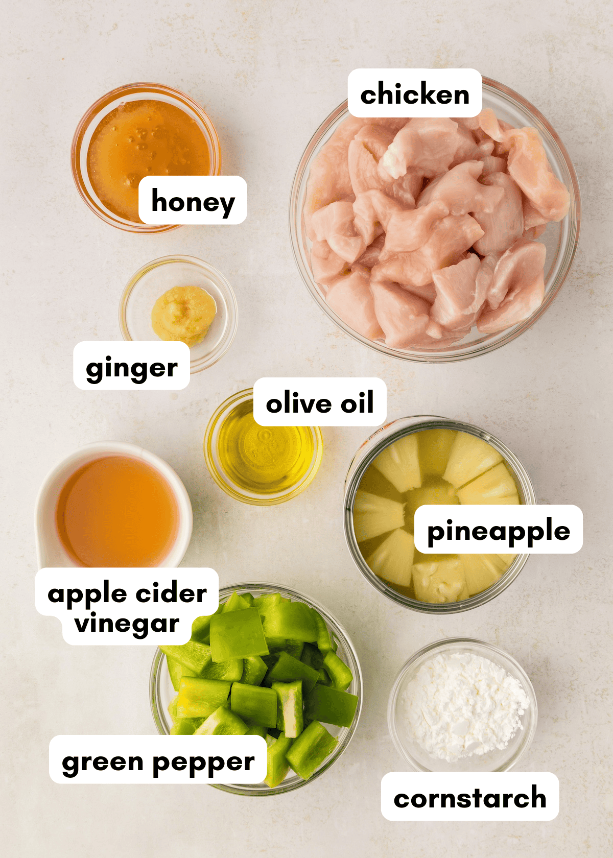 Bowls of Hawaiian chicken with pineapple, green pepper, honey, ginger, and olive oil.
