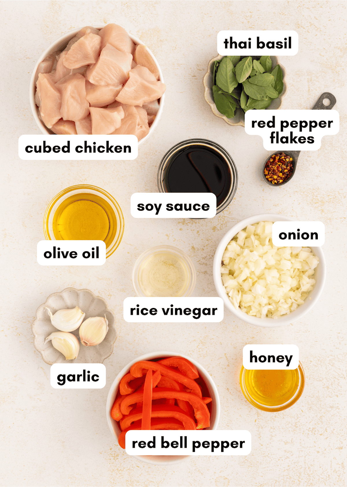 Thai Basil Chicken stir fry ingredients: cubed chicken, basil, soy sauce, onion, garlic, and more.